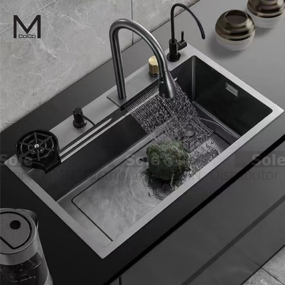 A black Mcoco kitchen sink with a single bowl, a shower faucet, and a cutting board, set in a counter with a modern design.